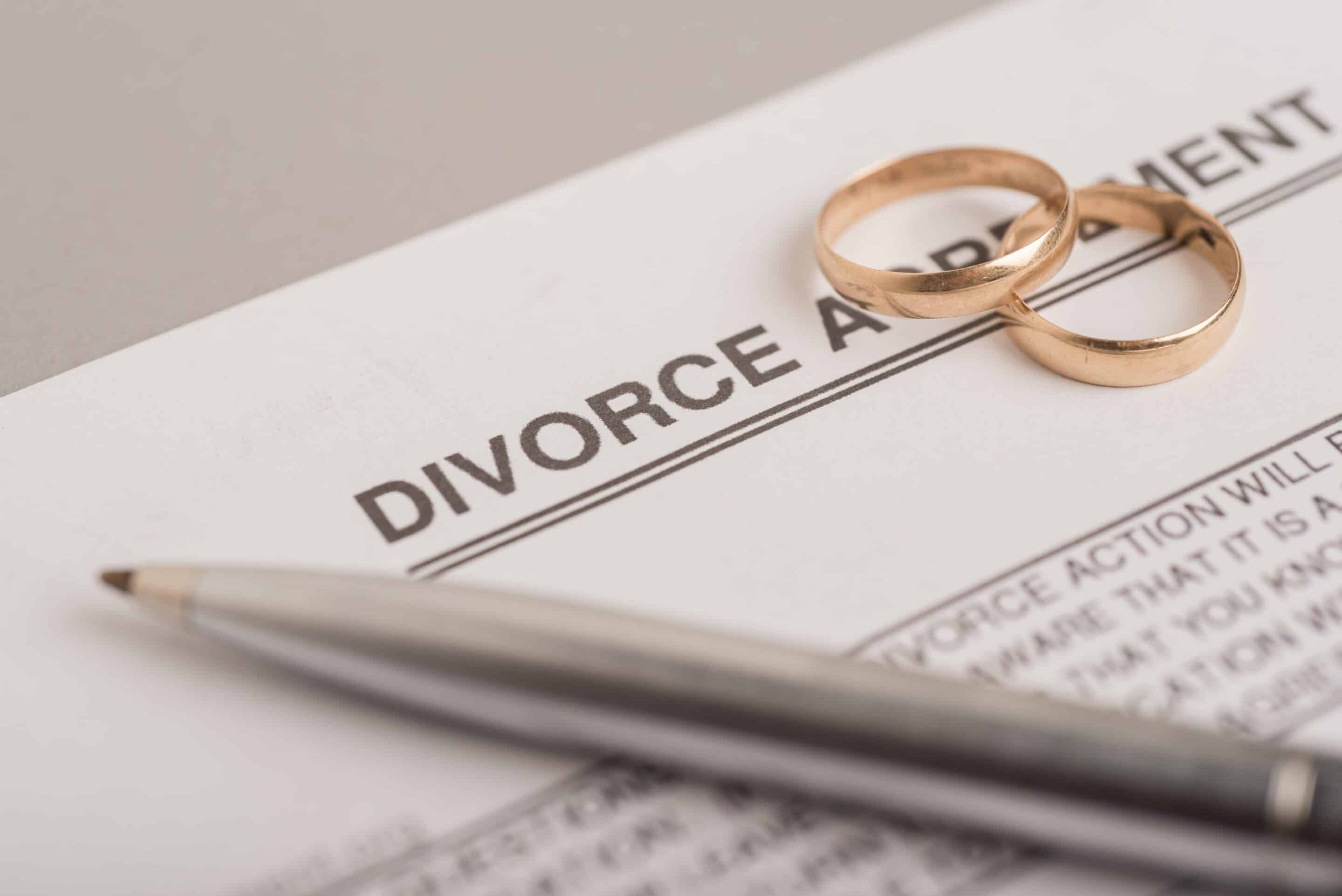 Divorce Agreement with pen and wedding rings