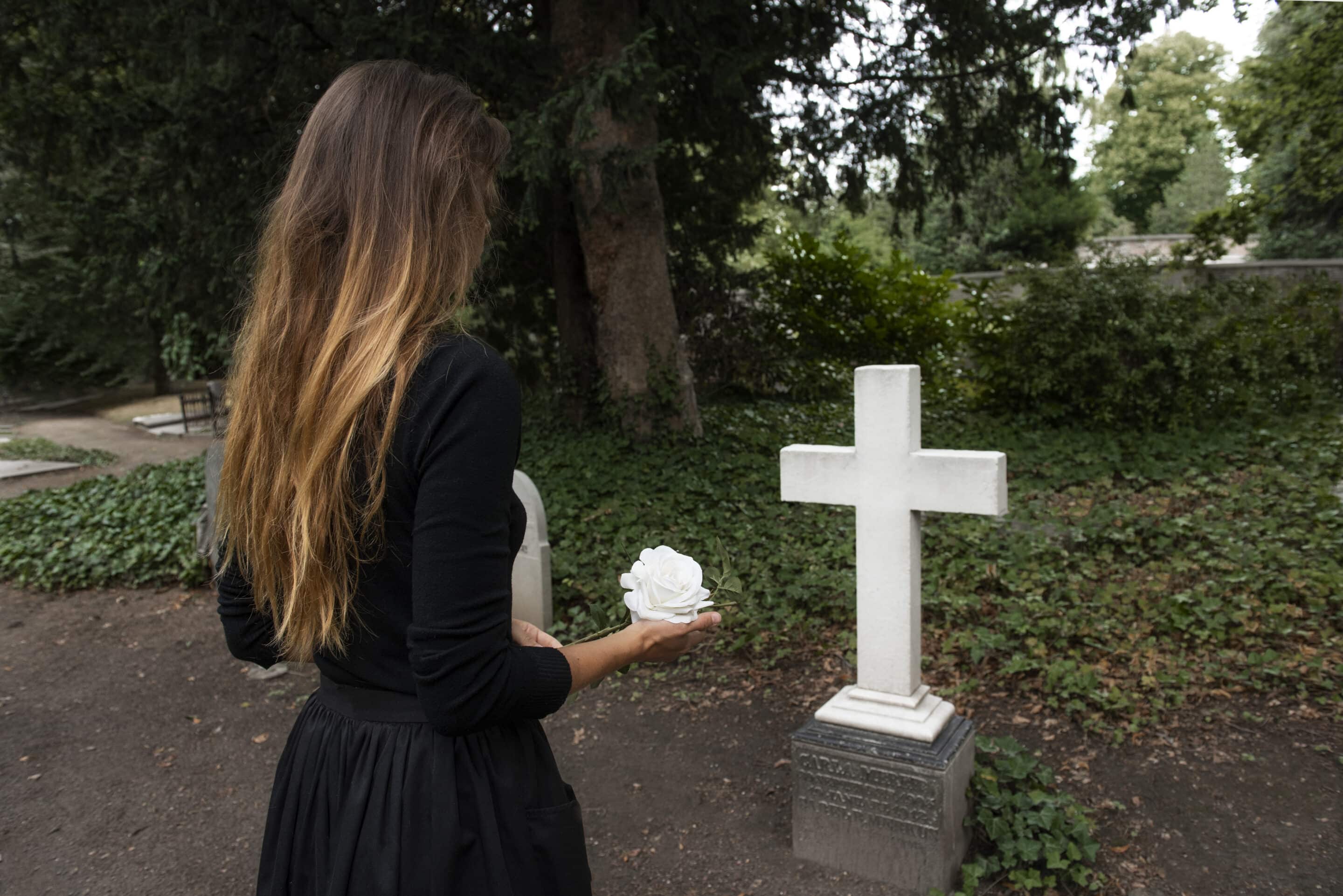 Woman in black standing at a tombstone