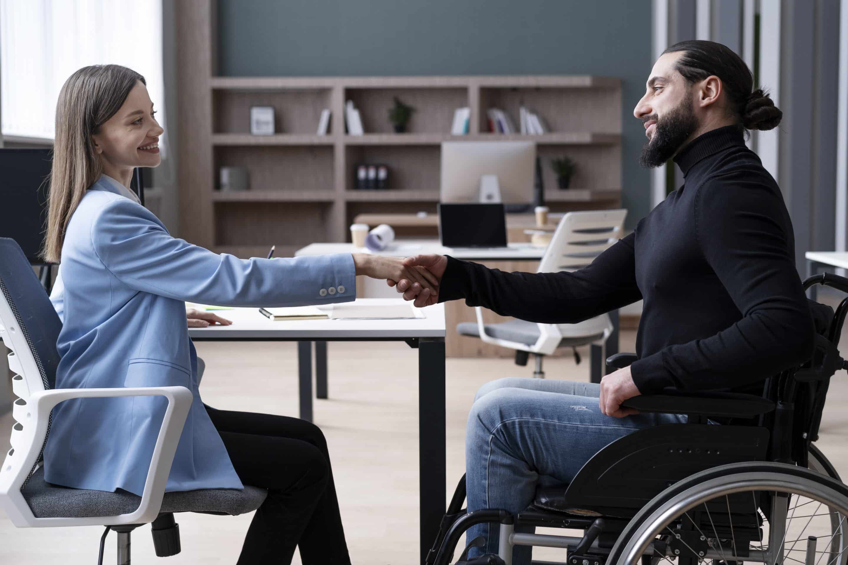 woman shaking hands with man in wheelchair